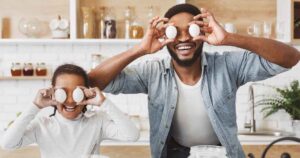 Pai e filha brincando colocando ovos na frente dos olhos