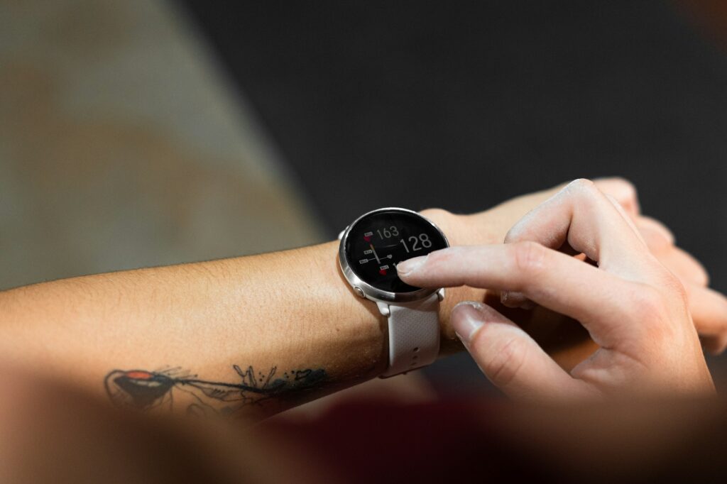 closeup sport watch on an arm of caucasian young woman with tattoo indicating the pulsation of the